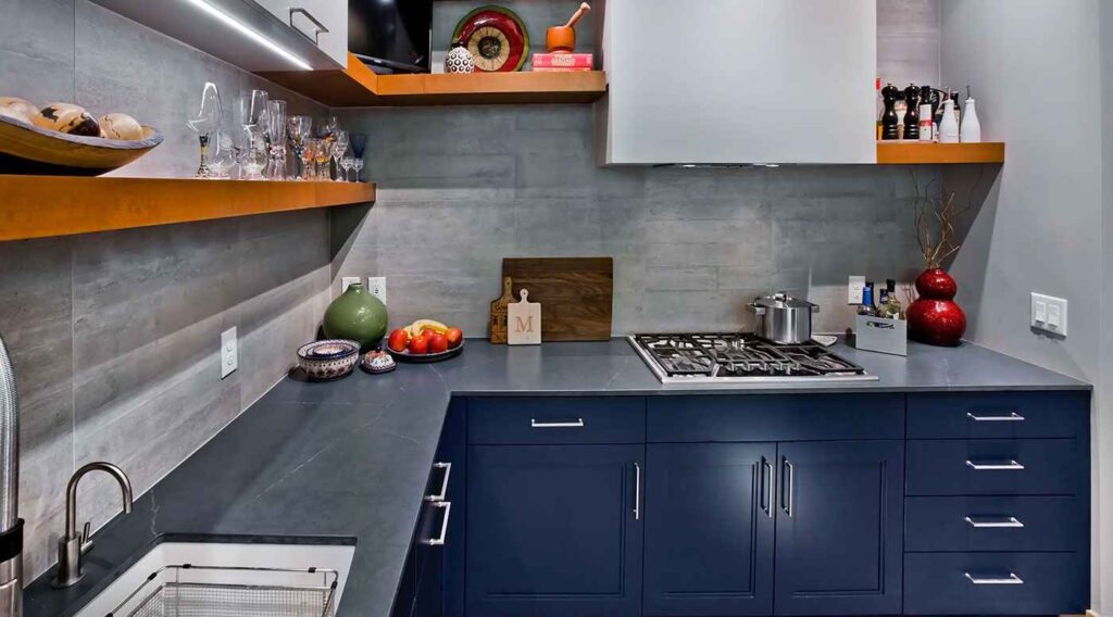 A navy blue cabinets and grey accents and white sink