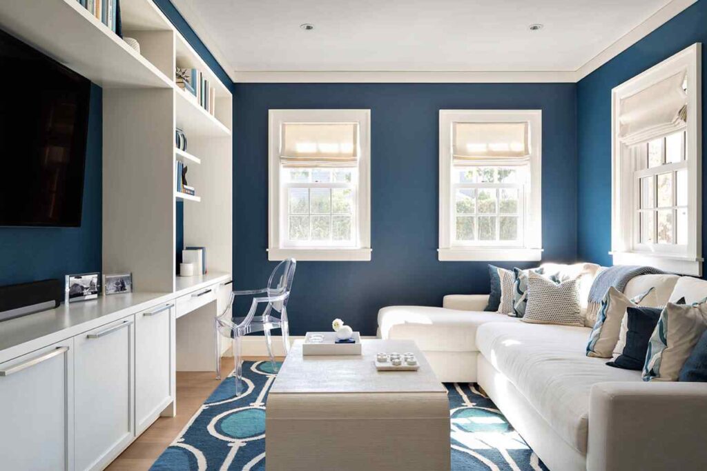A blue living room with white trim and blue rug on the wooden floor
