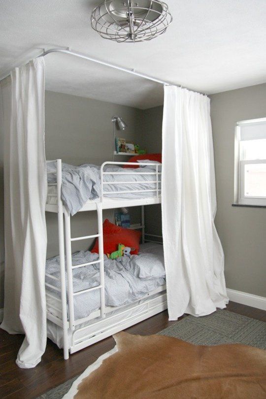 A loft bed with curtain with bed pillow on the bed