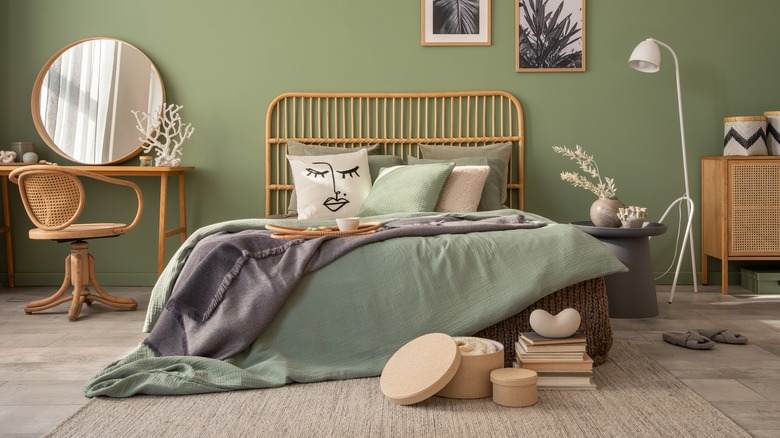 A sage green bedroom with mirror on the wall