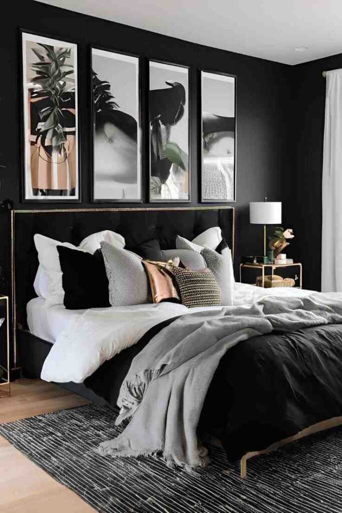 A black bedroom with gallery wall and wooden floor