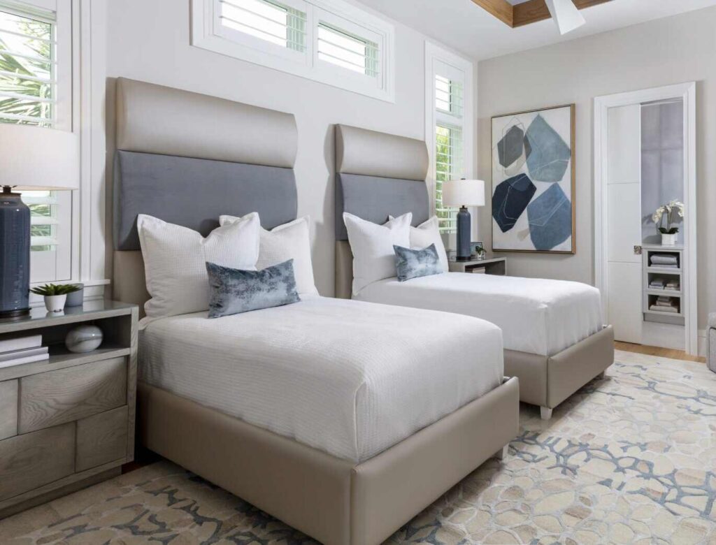 A bedroom with two beds with wall mount headboard