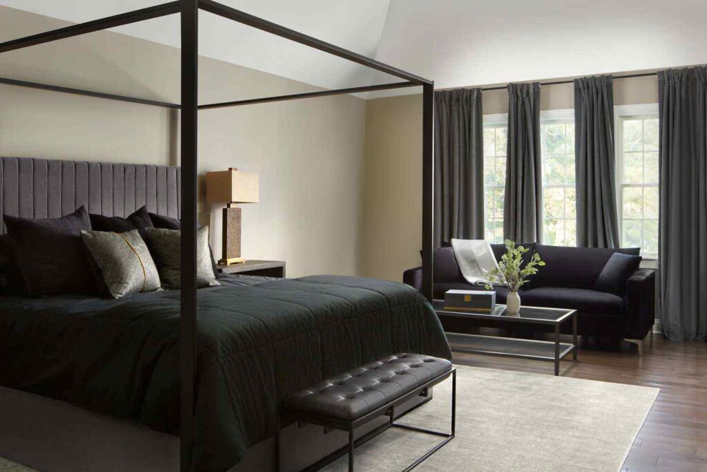 Linen curtains on window and a black bed with metal bed frame