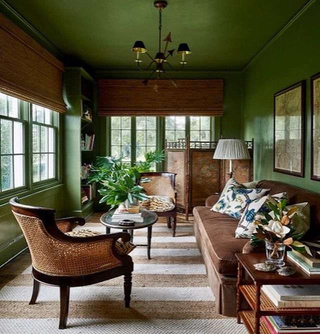 A green living room with wooden furniture and lights above the wall