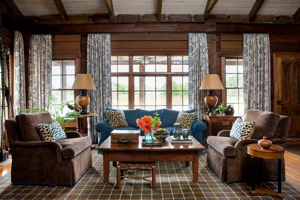 A cottage living room with wooden floor and windows and curtains