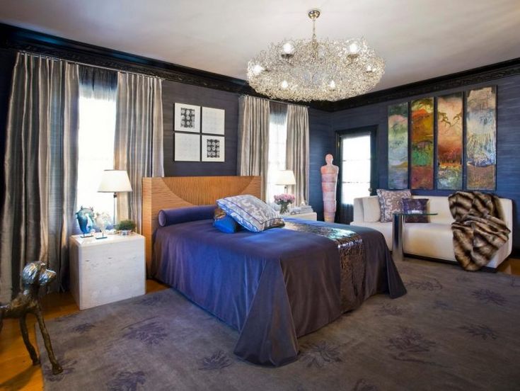 A blue and grey bedroom with Crystal chandelier and curtains with windows and wooden floor and grey rug on it