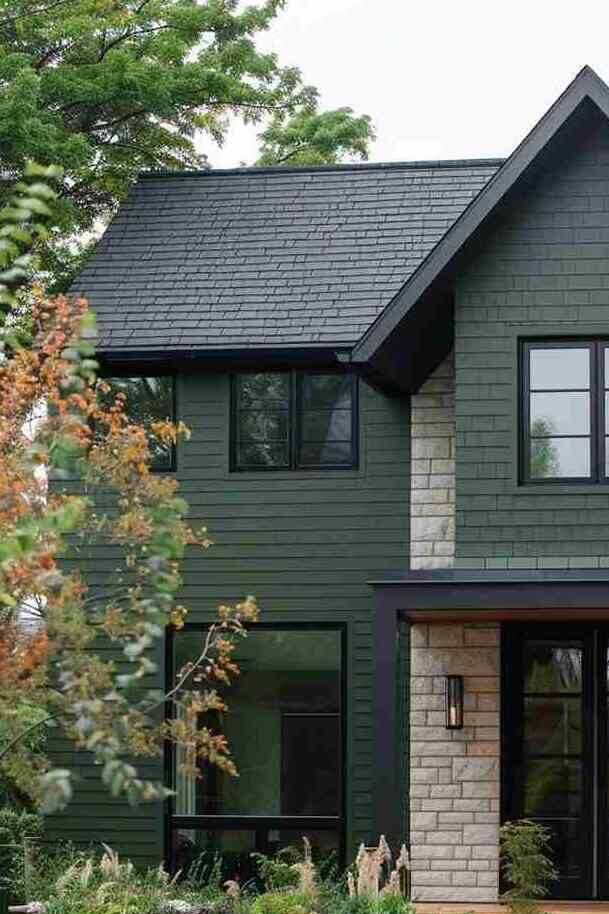 A green house with black trim and windows 