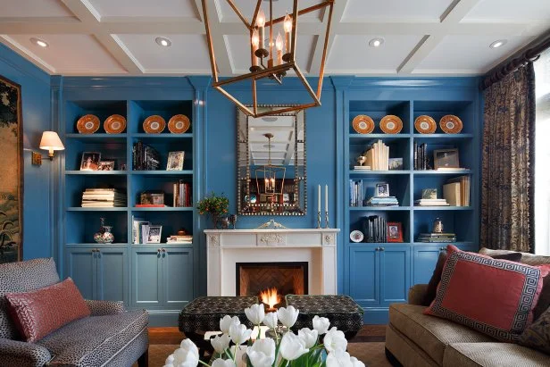 A blue living room with built shelves and white accents