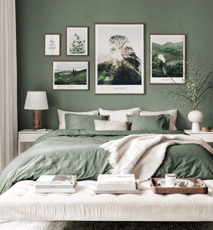 A sage green bedroom with framed on the wall and lamp on the side table