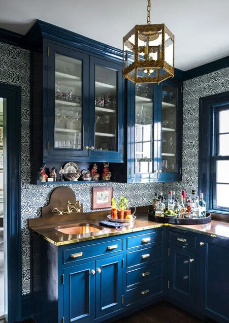 A navy blue cabinets and glass cabinets door ad wooden counter top