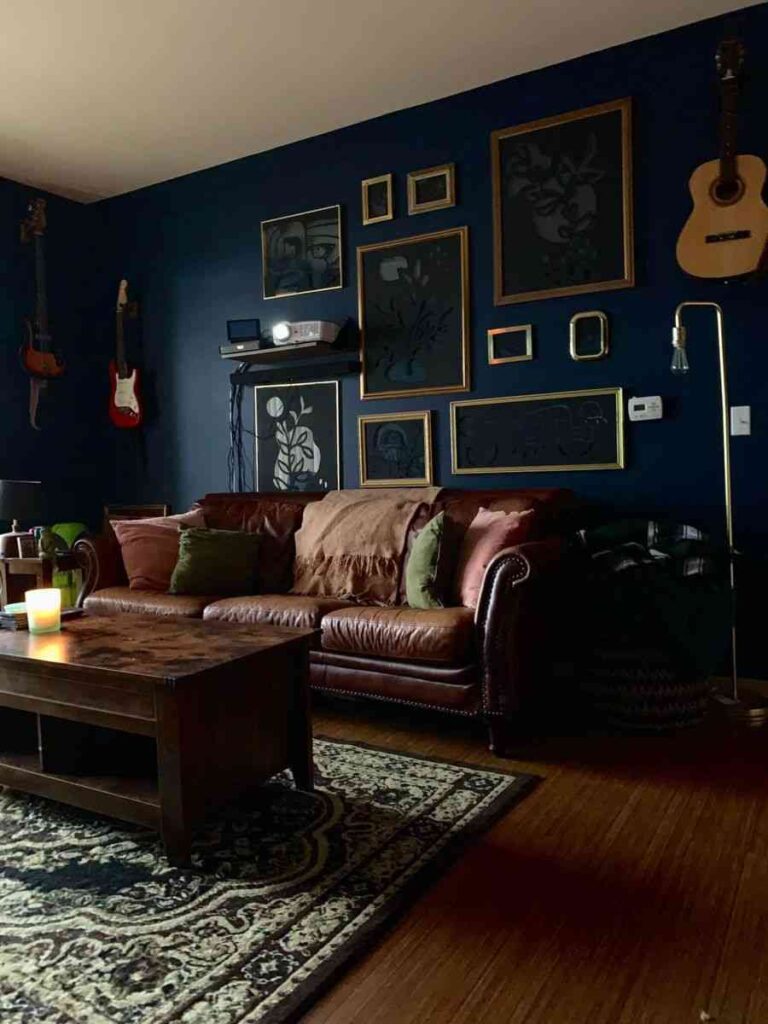A blue living room with with personalized frames wall and brown sofa