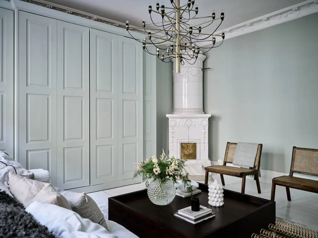 A sage green living room with grey wainscoting