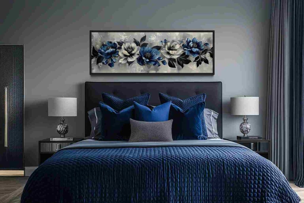 A grey bedroom with black bedding bed and grey and blue artwork on the wall and lamp on the nightstand