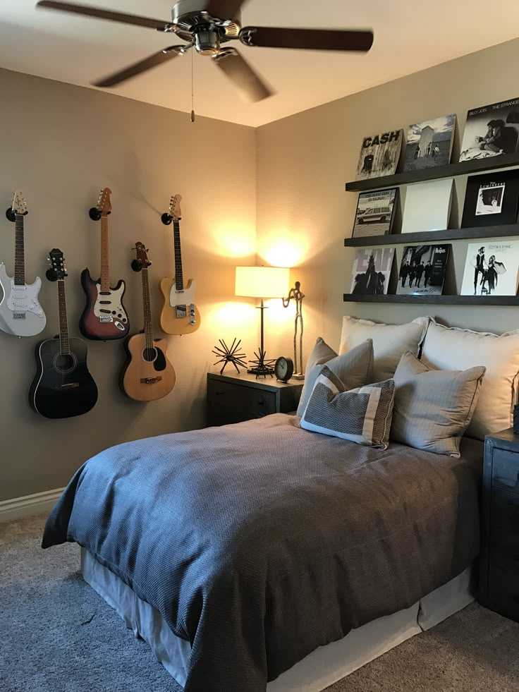 A bedroom with guitar on the wall and lamp on the nightstand