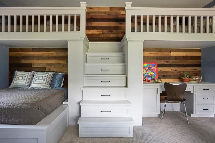 A bed with desk in a small room and wooden accents