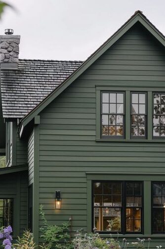 A green house with black lantern with windows 