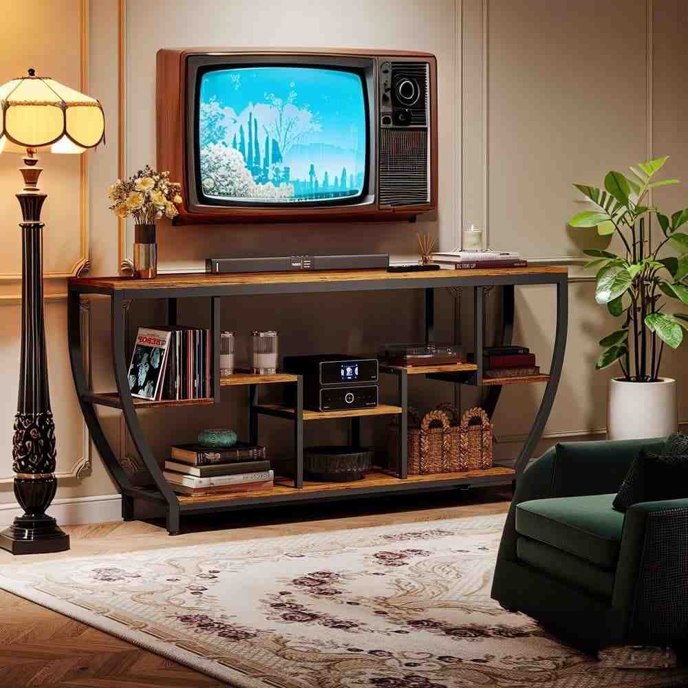 A living room with TV stand and wooden floor with rug on it and side lamp