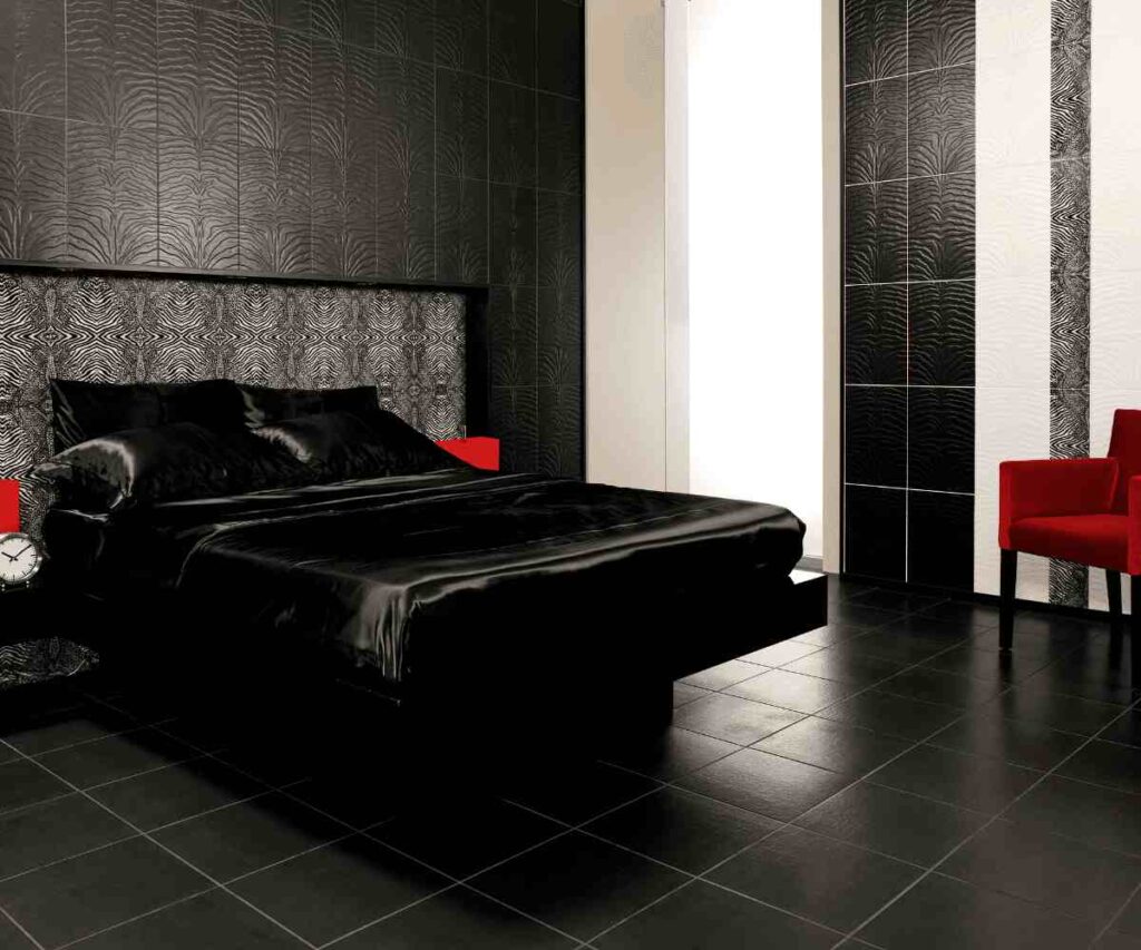 A black bedroom with white trim and black tiles flooring and red chair