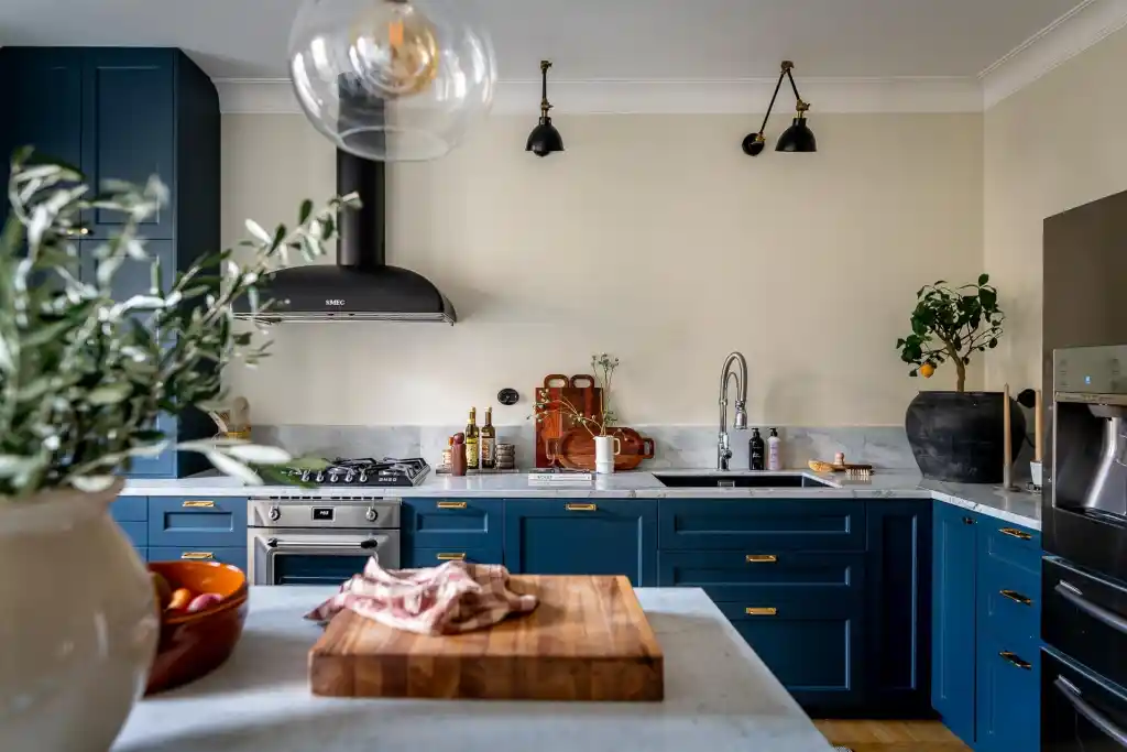 A navy blue kitchen with white accents and black fixtures