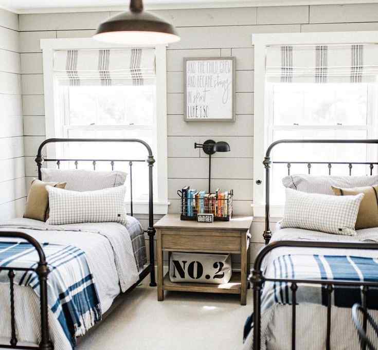 A iron framed beds and a table on middle of bed 
