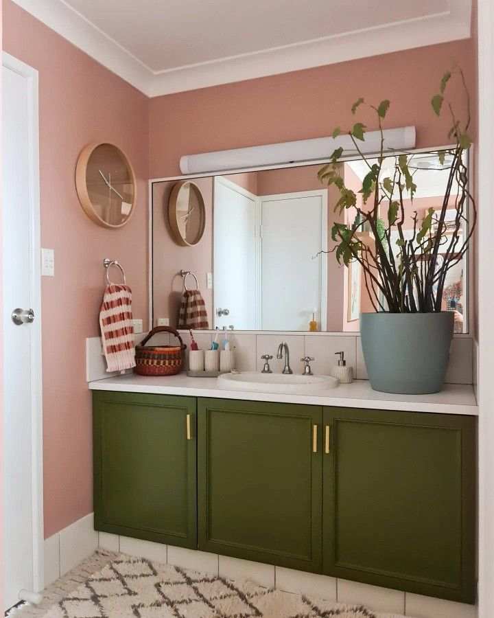 A pink and white trim bathroom with green vanity