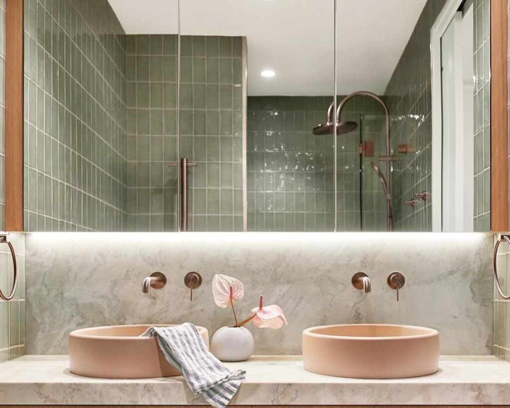 A pink basin in bathroom and mirror on the wall