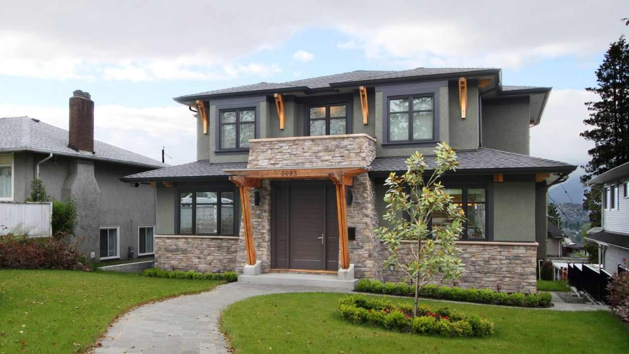 Sage green house with stone baseand wooden beams