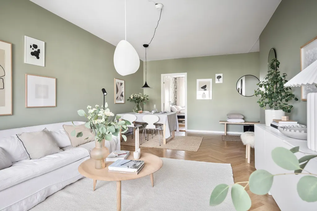 A sage green with white furniture with wooden floor