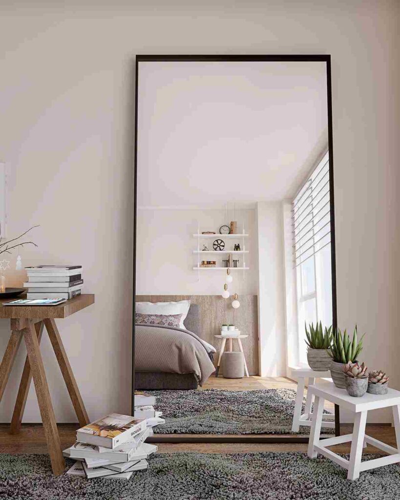 Standing black framed mirror in a bedroom