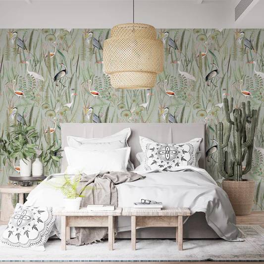 A sage green bedroom with sage and white wallpaper and grey bed with white pillows