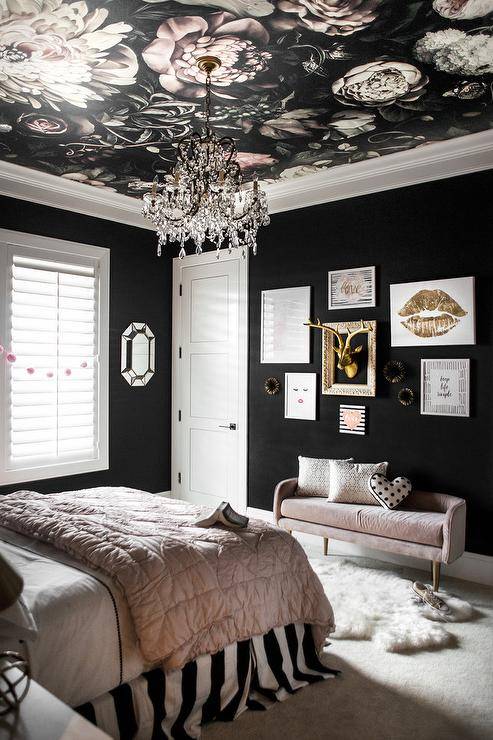 A black bedroom with white framed artwork on the wall
