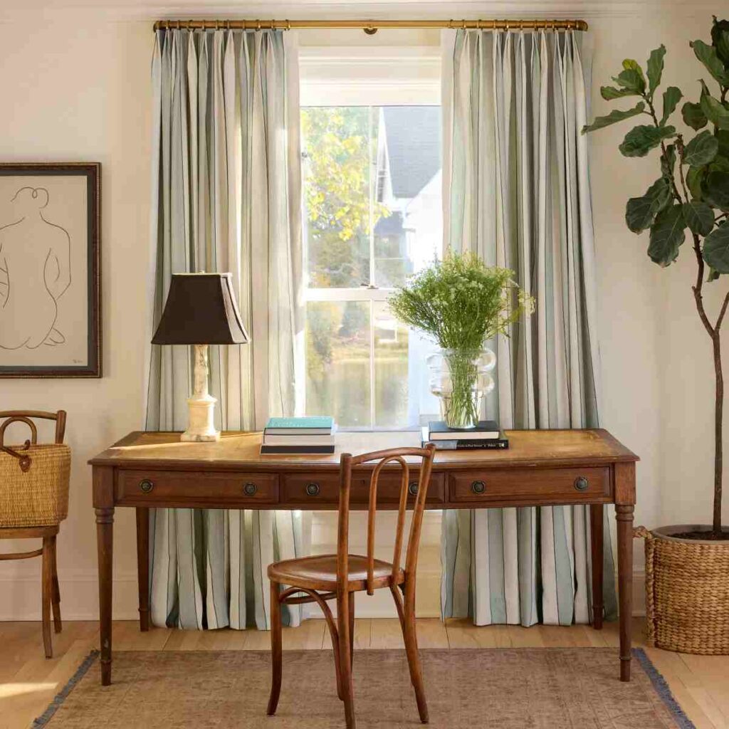 Wooden desk with a chair in office with wooden window with stripped curtains