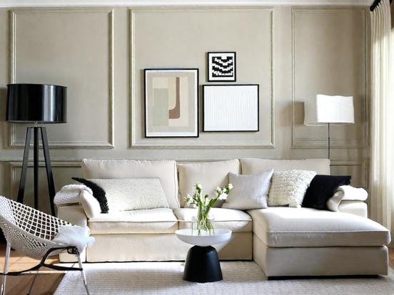 A beige living room with black accents  and rug on the floor 