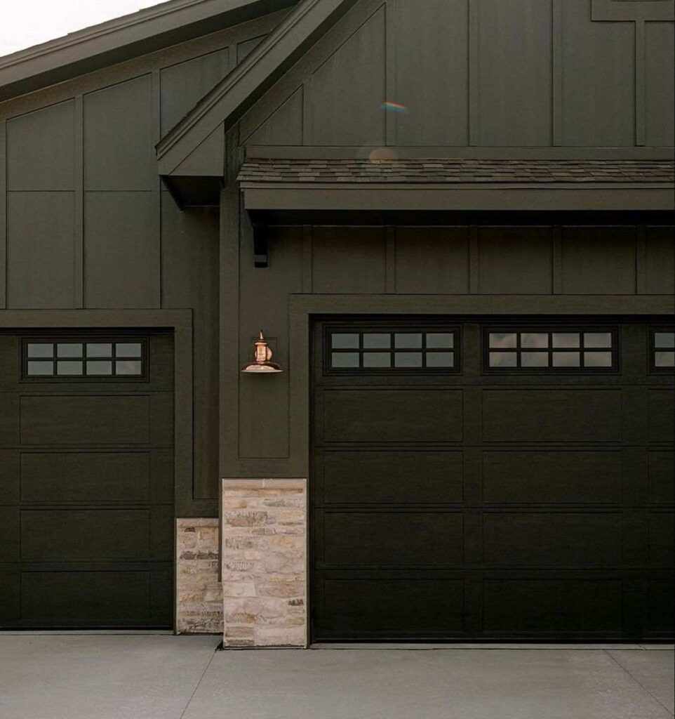 A dark green house with black garage 