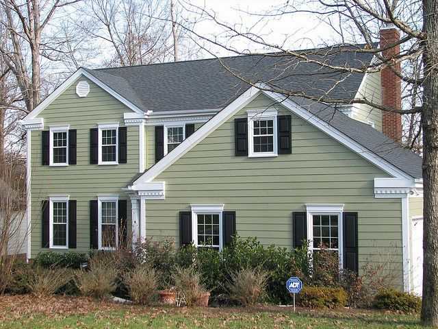 A sage green house with black shutter and white trim 