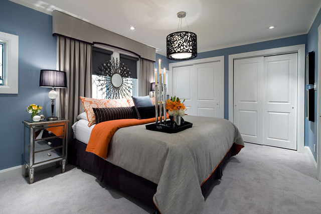 A bedroom with grey and blue and orange throw