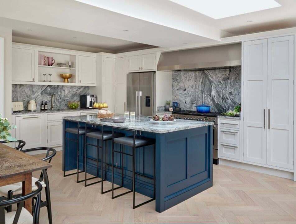 A kitchen with blue island and white counter top and wooden floor