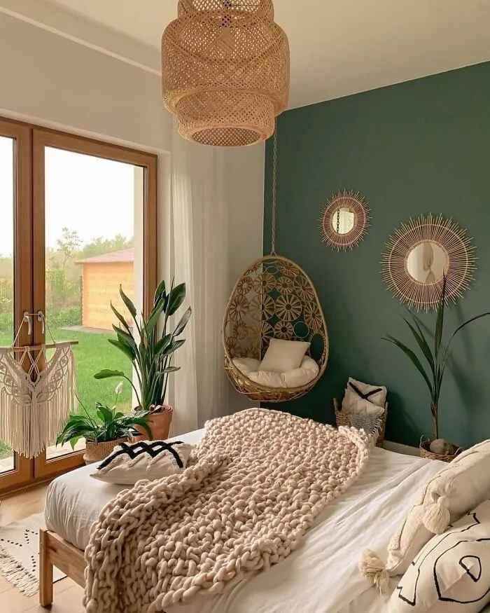 A sage green with wooden framed windows and mirror on the wall