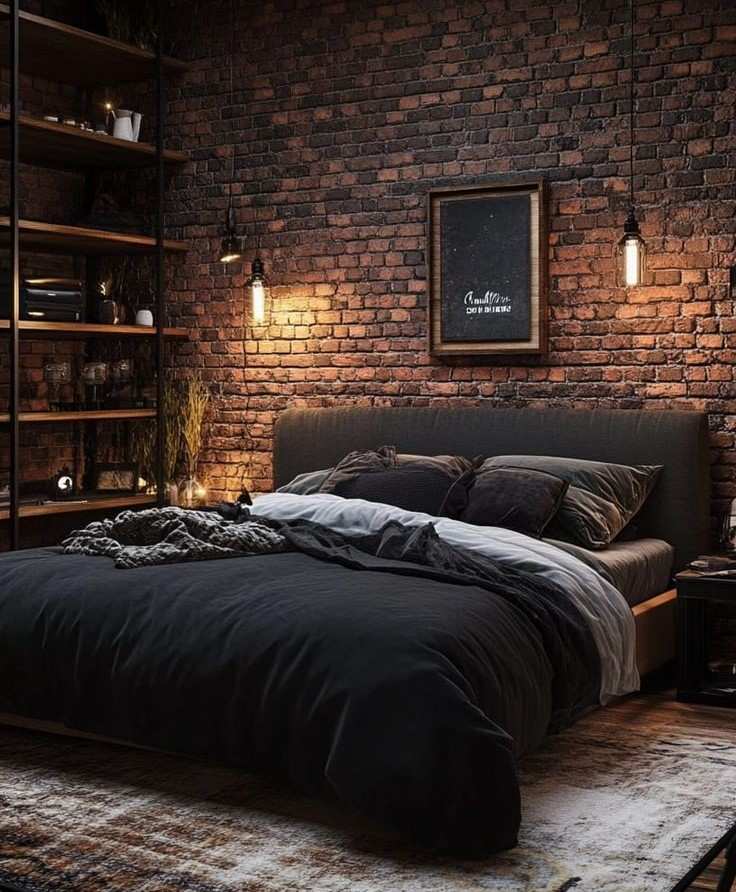 brick wall and black bedding with two ligts hanging above it