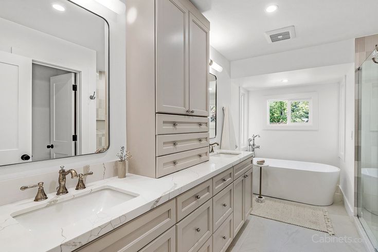 A shaker cabinets and mirror on the wall and white bathtub  