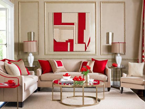A beige living room with red accents and table and lamp on the side table 