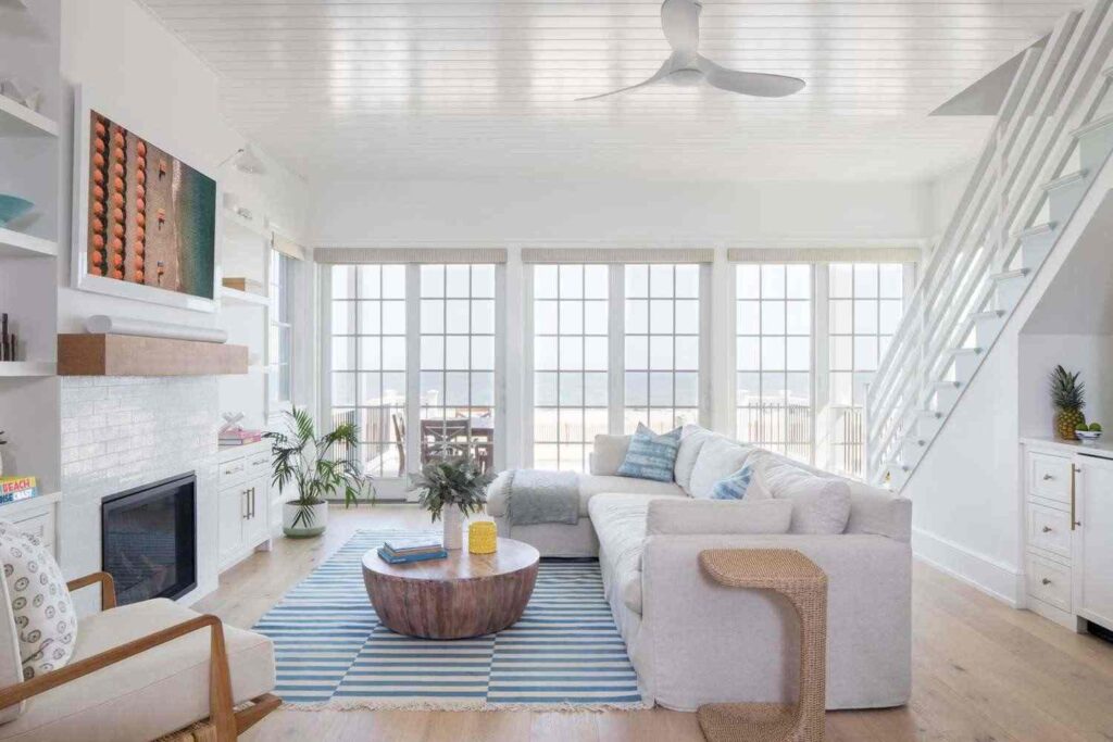 A living room with white room and wooden floor and rug on it
