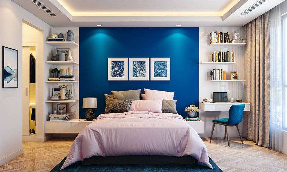 A blue and white bedroom with wooden floor and study table and chair and shelves
