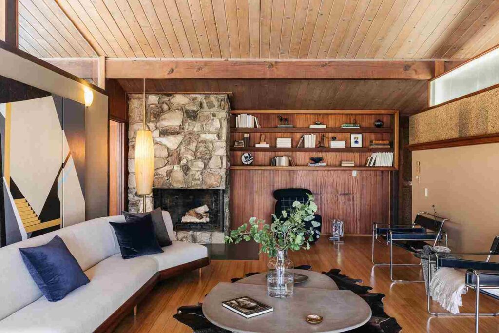 A mid century living room with wooden wall and celling and floor and sofa