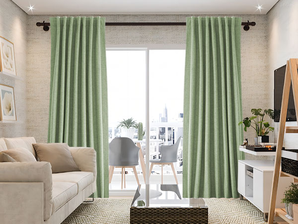 A sage green curtains with black rod and sofa and table