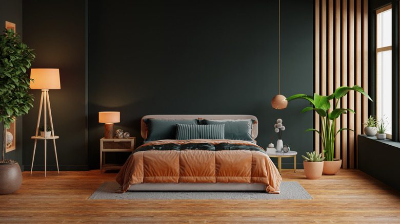 A brown tones in green bedroom with wooden floor and lights on the nightstand 