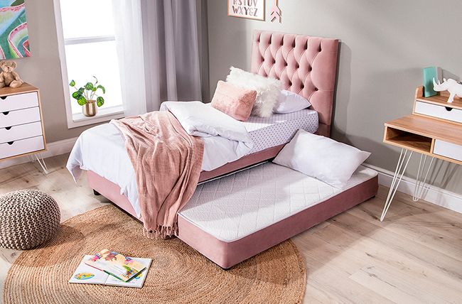 A dual function in bed and wooden floor and rug and side table 