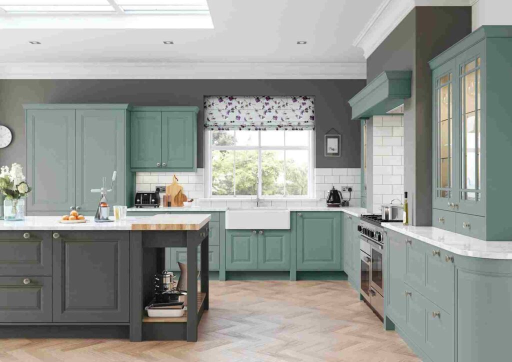 A sage and dark kitchen and wooden floor and white countertop and white sink
