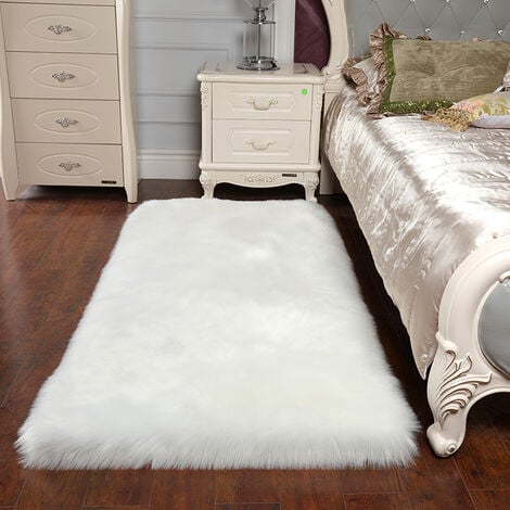 A faux fur rug in the bedroom with wooden floor and side nightstand