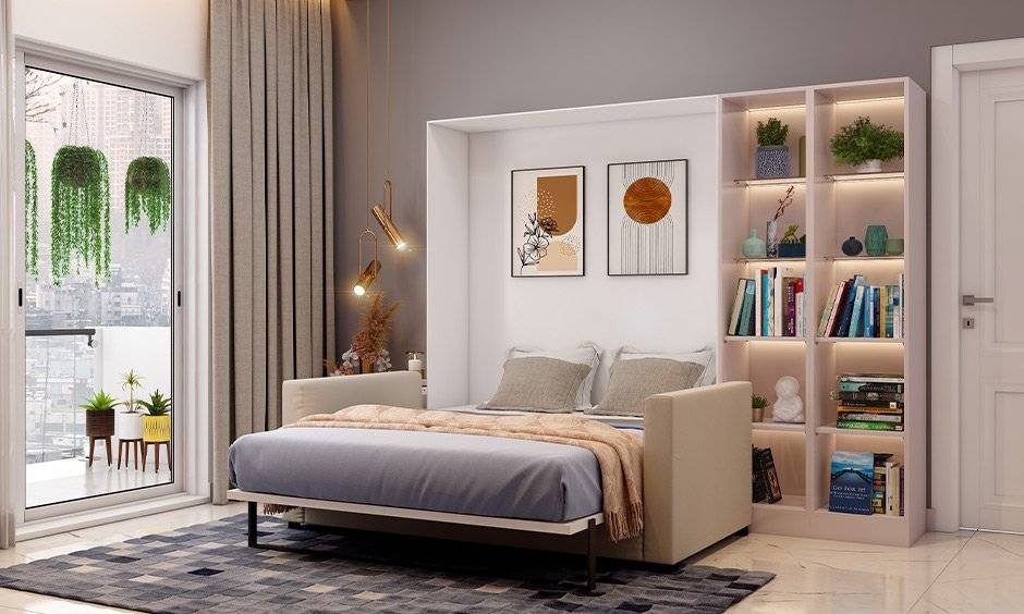 A bedroom with fold way bed and wooden floor and rug and book shelves 
